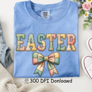 May include: A pale blue t-shirt featuring the word "EASTER" in patchwork lettering and a patchwork bow design. The shirt has a crew neck and short sleeves. The text "300 DPI Donloawd" is at the bottom.