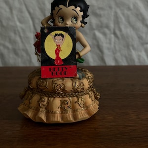Betty boop sitting holding a bouquet of roses!