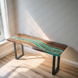 Può includere: Panca in legno realizzata a mano con un fiume di resina turchese e dettagli dorati. La panca ha un design a bordo vivo e poggia su gambe in metallo nero. Circa 152 cm di lunghezza.