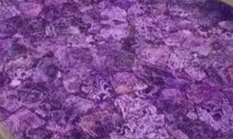 Puede incluir: Primer plano de una superficie con un patr&oacute;n de mosaico en tonos morados. El mosaico est&aacute; compuesto por piezas de forma irregular, creando una apariencia texturizada. La paleta de colores va del violeta intenso a los tonos lavanda m&aacute;s claros.