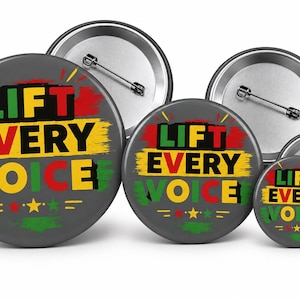 May include: Three circular pin-back buttons in varying sizes, each featuring a dark gray background with the text LIFT EVERY VOICE in black, yellow, and green. The design includes red, yellow, and green brushstroke accents and stars.