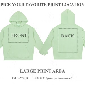 Pu&ograve; includere: Una felpa con cappuccio verde chiaro mostrata davanti e dietro, con un'ampia area di stampa rettangolare contrassegnata da linee tratteggiate. Il testo recita PICK YOUR FAVORITE PRINT LOCATION, FRONT, BACK, LARGE PRINT AREA e Fabric Weight 380 GSM.