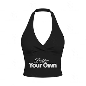 Pode incluir: Um top preto estilo frente única com um decote em V profundo e um detalhe cruzado no centro do peito. A parte frontal da peça exibe o texto branco "Design Your Own" numa combinação de fontes cursivas e sem serifa, centrado no tronco.