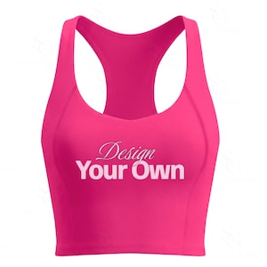 Puede incluir: Un sujetador deportivo de espalda cruzada en color rosa intenso con escote redondo y una banda ancha en el dobladillo. El centro del pecho muestra el texto "Design Your Own" en una combinación de fuente cursiva y letra de bloque.