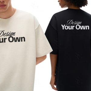 May include: A beige t-shirt with the text Design Your Own in black lettering on the front and a black t-shirt with the text Design Your Own in white lettering on the back. Both shirts feature short sleeves and a crew neckline in a simple design.
