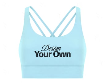 Może przedstawiać: Jasnoniebieski biustonosz sportowy z krzyżującymi się ramiączkami na plecach. Tekst "Design Your Own" jest wydrukowany czarną czcionką z przodu. Biustonosz ma okrągły dekolt i szeroki pas pod biustem.