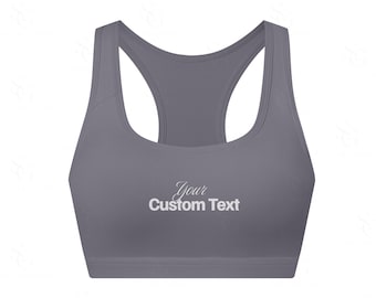 Może przedstawiać: Szary biustonosz sportowy z wycięciem na plecach. Biustonosz ma napis "Your Custom Text" w białej, kursywą czcionce z przodu. Biustonosz jest wykonany z gładkiego, jednolitego materiału.