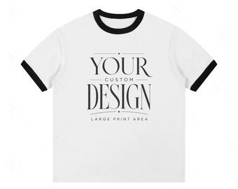 Może przedstawiać: Biała koszulka z czarnymi wykończeniami na kołnierzu i rękawach. Koszulka zawiera napis "YOUR CUSTOM DESIGN" klasyczną czcionką, z napisem "LARGE PRINT AREA" poniżej.
