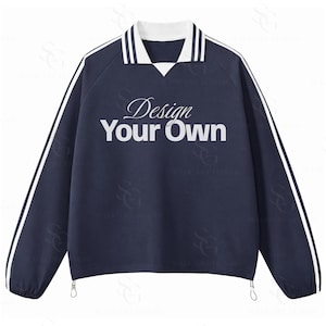May include: Navy blue long-sleeved shirt with white stripes down the sleeves and a white collar. The text "Design Your Own" is printed on the front. The shirt has drawstrings at the bottom.