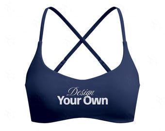 Może przedstawiać: Granatowy biustonosz sportowy z krzyżowym tyłem. Biustonosz posiada cienkie ramiączka i napis "Design Your Own" białym skryptem z przodu.