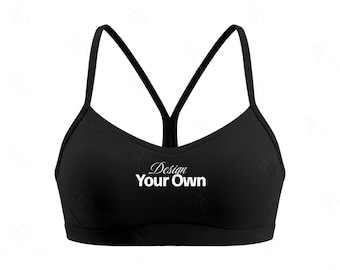 Może przedstawiać: Czarny biustonosz sportowy z cienkimi ramiączkami i krojem bokserki. Tekst "Design Your Own" jest wydrukowany na białym tle z przodu. Ten top sportowy jest odpowiedni do różnych ćwiczeń.