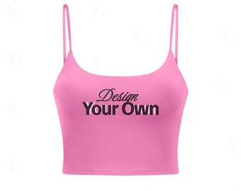 Może przedstawiać: Jasnoróżowy top z cienkimi ramiączkami. Na topie widnieje napis "Design Your Own" czarną czcionką z białym i różowym cieniem. Top jest w jednolitym kolorze.