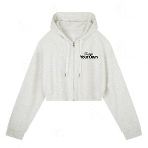 Può includere: Una felpa corta con cappuccio e zip in grigio chiaro mélange, dotata di maniche lunghe, cappuccio con coulisse abbinata e la scritta nera Design Your Own stampata sul lato sinistro del petto. Il capo presenta una chiusura a zip frontale.