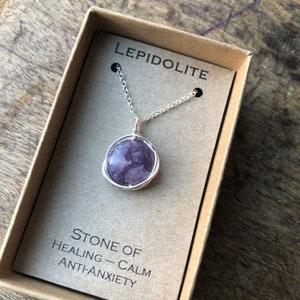 Pu&ograve; includere: Una collana a catena d'argento con un ciondolo in pietra di lepidolita viola avvolto in filo d'argento. La collana &egrave; in una piccola scatola con il testo "LEPIDOLITE" e "PIETRA DI GUARIGIONE - CALMA ANTI-ANSIA".