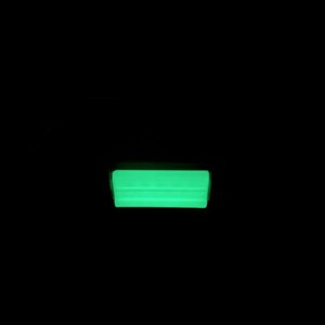 May include: A rectangular object emitting a bright, solid neon green glow against a completely black background. The light source appears uniform across the surface, creating a sharp, luminous horizontal bar shape that stands out in the darkness.