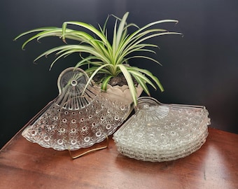 Set di sei piatti da dessert a forma di ventaglio in vetro pressato trasparente.