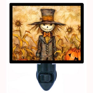 May include: A decorative night light featuring a whimsical scarecrow design. The scarecrow wears a top hat and a bow tie, standing in a field of corn and pumpkins. The artwork has a vintage, autumnal feel, perfect for Halloween.