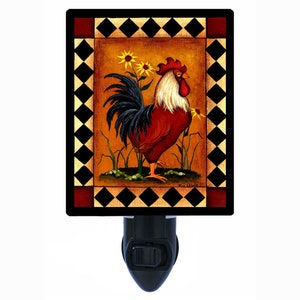 May include: A night light featuring a rooster with red, black, and white feathers standing in a field of sunflowers. The image is framed with a black and white checkered border.