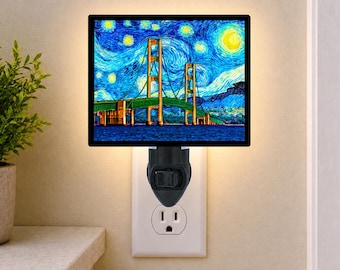 May include: A rectangular plug-in night light featuring a vibrant, swirling blue and yellow artistic print of a suspension bridge. The light is mounted on a black base and is plugged into a standard white wall outlet, emitting a soft glow.