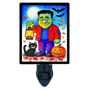 May include: A Halloween-themed night light featuring a cartoon Frankenstein's monster holding a lantern. A black cat, pumpkin, and bats are also depicted. The night light has a black base and a rectangular image.
