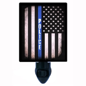 May include: A night light with a blue and white American flag design. The flag has a thin blue line down the center with the word "POLICE" printed vertically on the line.