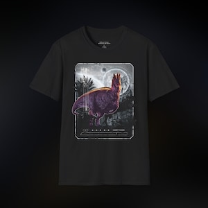 May include: Black t-shirt featuring a purple dinosaur graphic within a white rectangular frame. The design includes a full moon and jungle foliage. The text "PRIMAL HORIZON" is printed at the top.