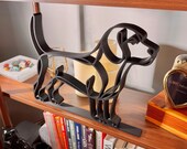 Three-quarter angle of a large Beagle line art sculpture on a wooden bookshelf with vintage decor, glassware, and colorful cookbooks below — oversized 3D printed minimalist beagle home decor and a heartfelt beagle gift idea for shelves, mantels, and dog lover homes.