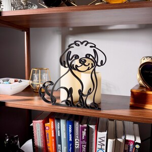 Close-up of a matte black Maltipoo line art sculpture in profile, glowing candles backlighting the fluffy curly silhouette — 3D printed minimalist Maltipoo decor and a unique Maltipoo gift for Maltipoo moms, doodle dads, and dog lovers who love modern shelf decor.