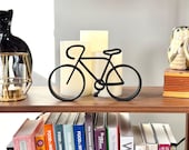 Contemporary bicycle line art sculpture styled on a home bookshelf, sleek cycling-themed decor perfect gift for cyclists, triathletes, and bike lovers.