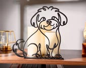 Matte black Maltipoo line art sculpture sitting on a wooden display shelf with warm candlelight behind it and colorful books below — modern 3D printed dog decor and a sweet Maltipoo gift for doodle dog moms, Maltipoo owners, and cute teddy-bear-style dog art fans.