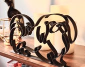 Close up of black Pekingese minimalist line sculpture on wooden shelf, modern Pekingese dog lover gift and tabletop home decor piece