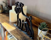 Schnauzer dog statue in continuous line art, matte black finish, styled with candles and greenery for home decor.