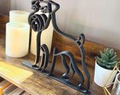 Modern Schnauzer silhouette decor, 3D printed in sleek black line art style, shown from side angle on bookshelf.
