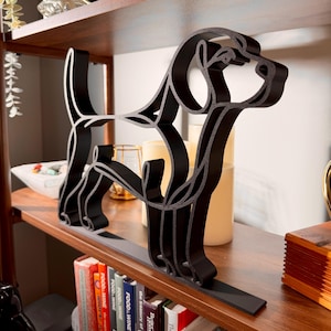 Close-up of a large matte black Beagle line art sculpture highlighting the breed's long floppy ears, sweet hound face, and continuous-line silhouette, styled on a wooden shelf with bookshelf and candles — oversized 3D printed beagle decor and a thoughtful beagle gift for dog moms and hound lovers.