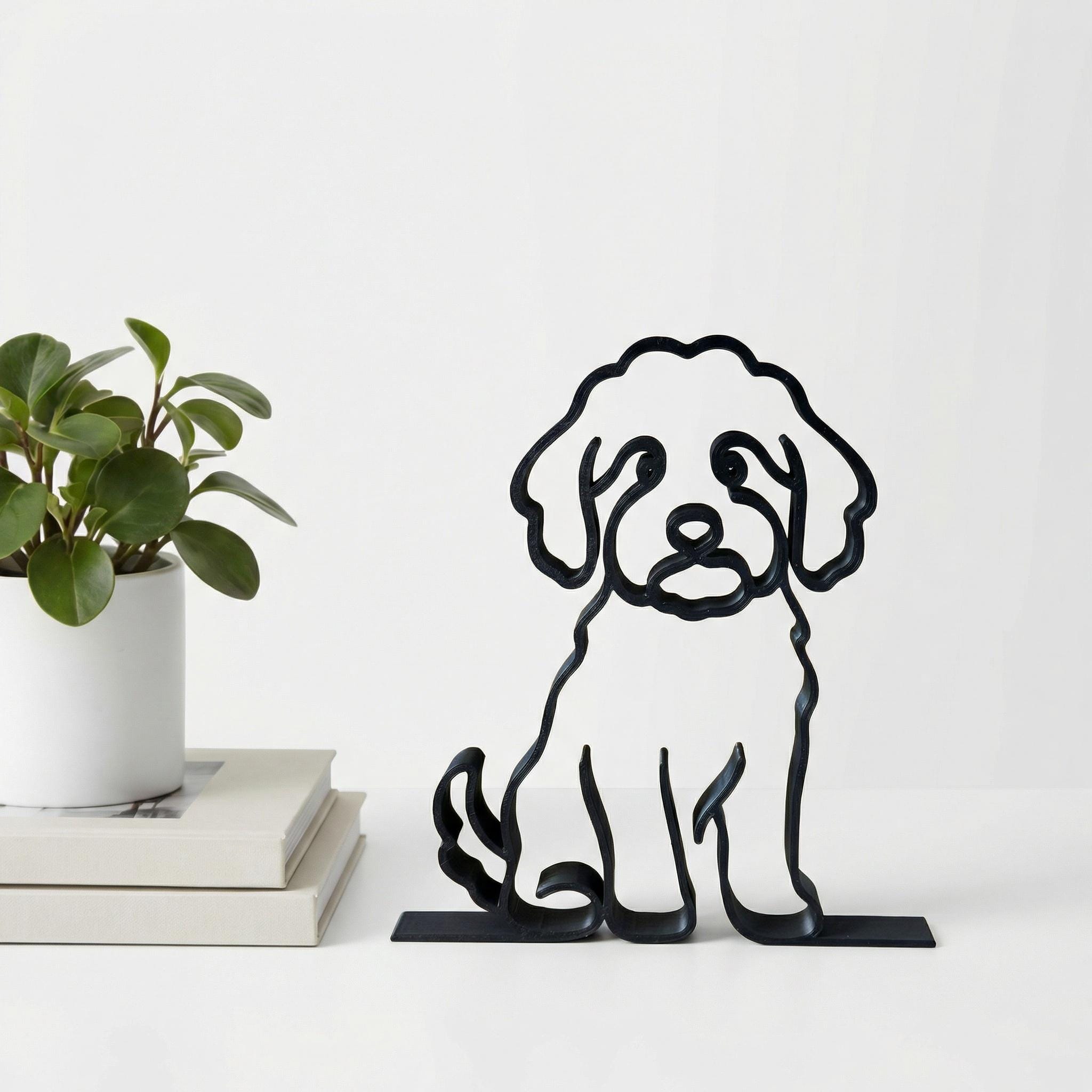Matte black Goldendoodle line art sculpture displayed on styled bookshelf with books and plants