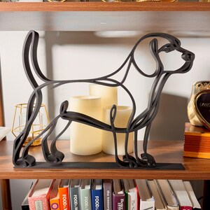 Side profile of a large Beagle line art sculpture on a wooden shelf with glowing pillar candles and a colorful bookshelf below — modern oversized 3D printed beagle home decor, minimalist hound silhouette, and a personal beagle gift for dog moms, beagle owners, and dog lovers.