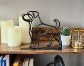 Rottweiler decor piece styled on a shelf next to candles, books, and plants.