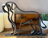 Black minimalist Saint Bernard line art sculpture on wood shelf with candles, succulent, and gold decor – modern dog lover home decor.