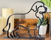 Minimalist Newfoundland Dog line art sculpture in matte black, displayed on a wooden shelf with candles and a plant. Modern 3D printed dog decor perfect for Newfoundland owners and pet lovers. Handmade sculpture with sleek single-line silhouette style, designed as contemporary home decor, shelf accent, or dog lover gift. Lightweight yet durable PLA statue adds unique personality to living rooms, offices, or mantels.