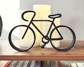 Minimalist black bicycle line art sculpture displayed on a bookshelf with candles, modern cycling decor gift for cyclists, bike lovers, and road cycling enthusiasts.