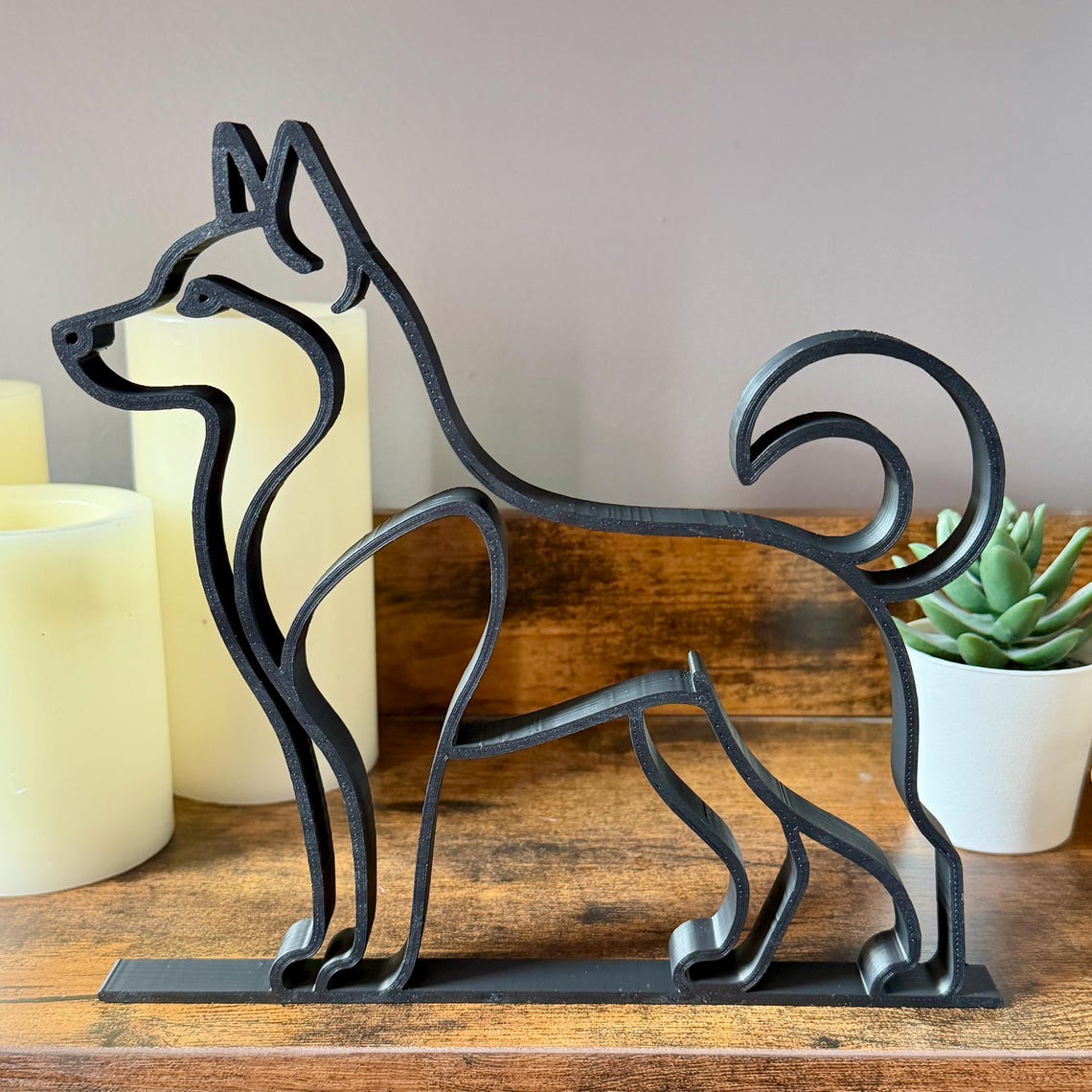 Close-up of Husky silhouette statue with curled tail and alert stance, modern dog shelf accent