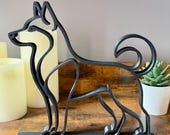 Close-up of Husky silhouette statue with curled tail and alert stance, modern dog shelf accent