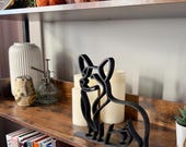 Modern Corgi shelf sitter figurine for dog lovers, black silhouette line art home decor accent on rustic bookshelf.