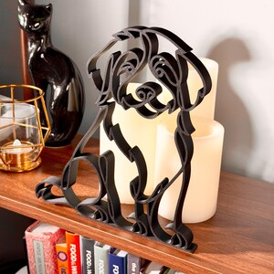 Detail view of a Bernedoodle line art sculpture highlighting the breed's curly doodle coat, sweet face, and continuous-line silhouette, backlit by warm candlelight on a wooden shelf — modern 3D printed Bernedoodle home decor and a heartfelt Bernedoodle gift for dog moms, dog dads, and doodle families.