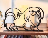 Pekingese line art sculpture in black standing on wooden bookshelf next to flameless candles above cookbooks, minimalist dog mom home decor gift