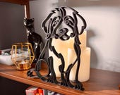 Close-up of a matte black Bernedoodle line art sculpture showing the breed's fluffy curly coat and gentle expression, styled with vintage candles, glass lantern, and cookbooks — 3D printed minimalist Bernedoodle decor and a unique Bernedoodle gift for doodle moms and dog lovers.