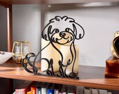 Sitting Maltipoo line art sculpture with detailed fluffy curly coat displayed on a wooden shelf with warm glowing candles and a colorful bookshelf in the background — minimalist 3D printed Maltipoo decor and a heartfelt Maltipoo gift for dog moms, doodle owners, and cute dog lovers.