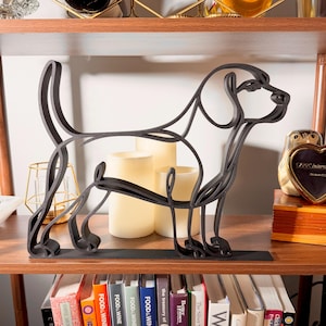 Large Beagle line art sculpture in standing profile displayed on a wooden shelf with warm glowing candles, a vintage clock, and colorful books below — oversized 3D printed beagle decor and a statement-size beagle gift for beagle owners, hound lovers, and dog moms who love minimalist home decor.