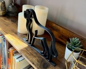 Saint Bernard dog line art figurine on wooden shelf with books, candles, and plants – stylish handmade dog lover gift.