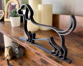 Side angled view of the miniature dachshund line art sculpture showing its elongated body and stable base. A sleek modern dog silhouette perfect for office shelves or home styling.